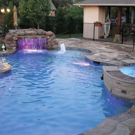 Custom in ground spa with spillway into a swimming pool